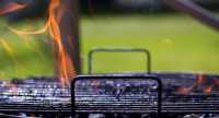 eldslågor slår upp från grill