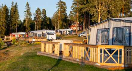 Husvagnar med förtält och träaltaner på en campingplats