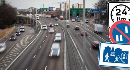 Trafik på motorväg med infällda trafikskyltar