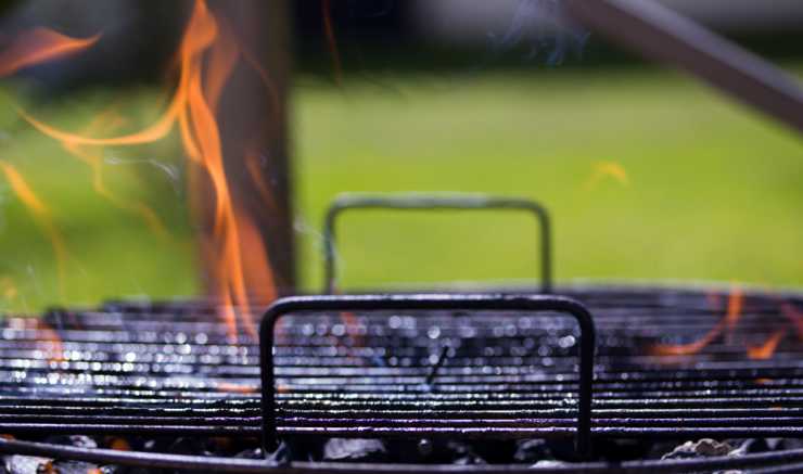 eldslågor slår upp från grill