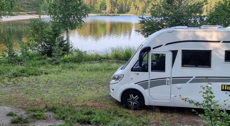 Husbil står på gräs vid sjö