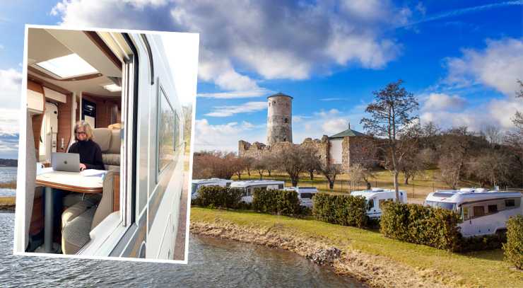 Kvinna sitter i husbil, husbilar parkerade nedanför slottsruin.