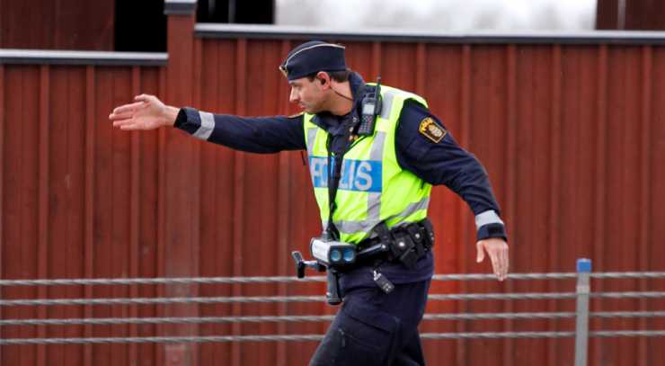 Polis går framåt och pekar med högerhanden