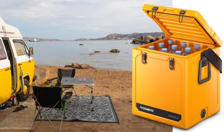 Gammal husbil på strand med gul kylbox från Dometic