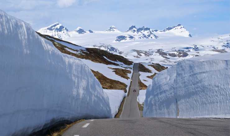 Vindlande väg genom snöigt landskap i Norge