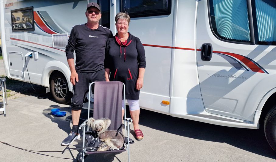 Bosse Johansson och Inge-Marie Linder med sin värmeälskande hund Peppe, på Söderhamns Citycamping. Man och kvinna och hund framför husbil