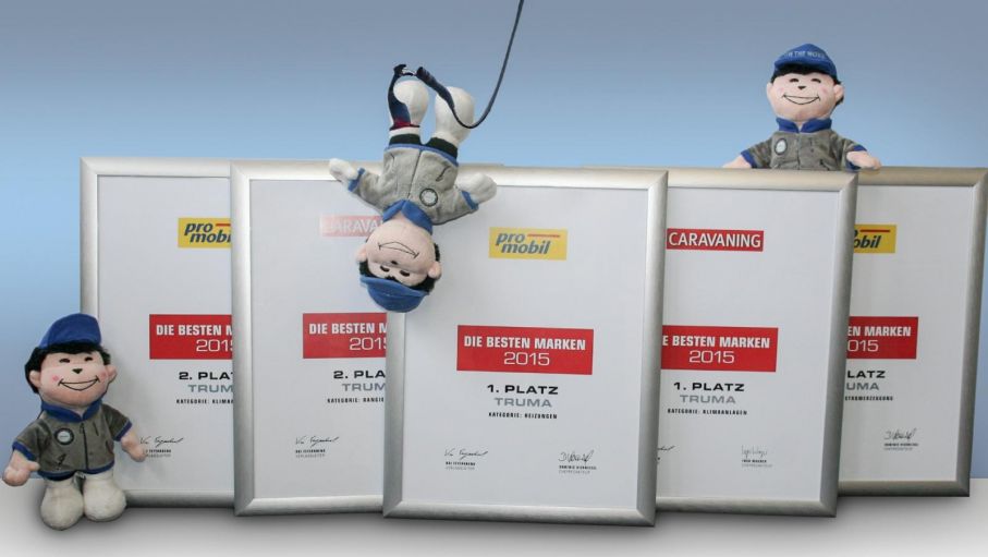 Den glada figuren som klättrar runt bland diplomen är Trumas maskot Nanuk.