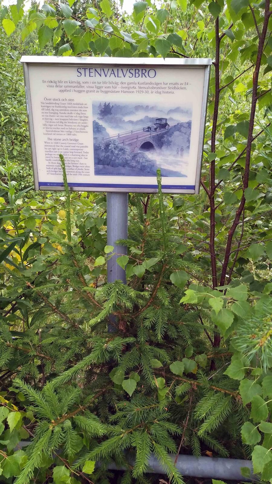 På andra sidan E4, från campingen sett, fortsätter gamla kustlandsvägen och där finns denna lite igenvuxna skylt som informerar om stenvalvsbron intill.