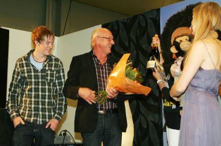 Robin och Tore Johnsson, ansvariga för ställplatsen i Böda hamn, tar emot priset av Husbil & Husvagns chefredaktör Carola Eklundh på Caravan Show i Kista. Prisutdelningen aviserades av Zillah & Totte som uppträdde på mässan.